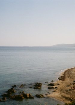 A body of water with a beach and mountains in the background