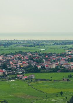 A city nestled between fields and the sea.