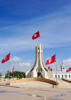 A monument with flags flying in the wind