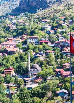 A red flag flying in front of a small village
