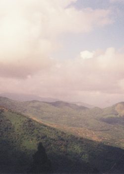 A scenic view of a mountain range with clouds in the sky