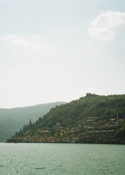 a body of water with buildings and hills in the background