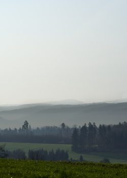a lake surrounded by trees and hills