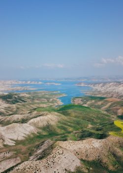 a landscape with hills and a body of water in the distance