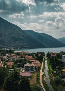 a scenic view of a town with mountains in the background