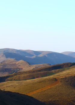 a view of a mountain range from the top of a hill