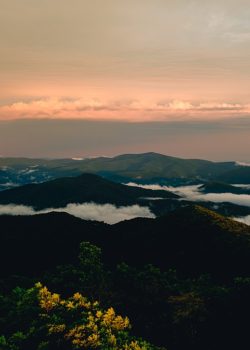 a view of a mountain range with low lying clouds