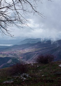 a view of a valley and mountains from a hill
