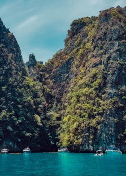 green and brown mountain beside body of water during daytime